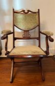 An arts and crafts style folding parlour / campaign chair with upholstered back and seat