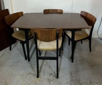 A Mid Century teak dining table and four chairs and centre leaf