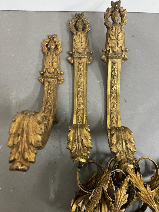 A pair of gilt bronze curtain pole holders with scrolling arms and Latrell leaf crowns