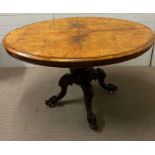 A walnut center table on scrolling feet and castors (73cm x 89cm x 124cm)