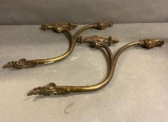 A pair of Rococo style gilt and bronze curtain pole holders and a pair of tie backs