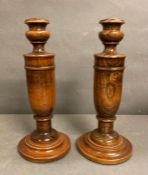 A pair of turned oak candle sticks