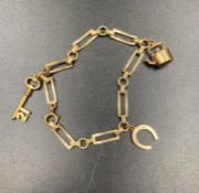 A 9ct gold charm bracelet with three charms (Approximate Total weight 8.1g)