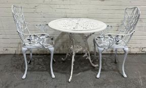 A metal garden bistro table and two chairs and a green parasol