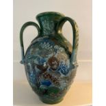 A CH Brannam art pottery three handled vase. An earthenware vase decorated in relief design. the