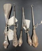 A selection of five silver handled dressing table items to include two button hooks, a shoe horn,
