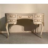 A white painted Louis style dressing table on cabriole legs and gold fleur detail