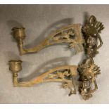 A pair of brass wall mounted candle holders with a floral motif