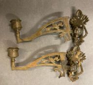 A pair of brass wall mounted candle holders with a floral motif
