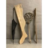 A vintage umbrella, a carpet beater and two wooden decorative legs