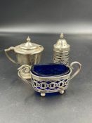 Three hallmarked silver cruets to include a mustard, salt and a pepper pot all with blue glass