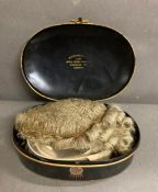 A boxed legal wig in a tin box