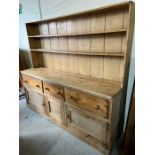 A pine farmhouse dresser with a plate rack and deep drawers and cupboards under (228cm x 200cm x