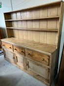 A pine farmhouse dresser with a plate rack and deep drawers and cupboards under (228cm x 200cm x