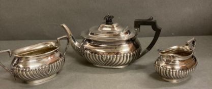 A white metal tea pot, sugar bowl and milk jug