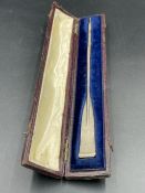A white metal oar on cased box 18.5 cm long