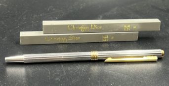 A Christian Dior silver pen and two packets of refills