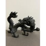 A cast metal dragon with fire ball (H27cm W40cm)