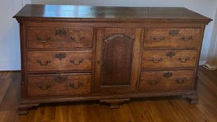 A George III style oak server with six drawers and a centre cupboard and brass handles (H93cm W180cm