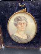 A miniature portrait, signed H M K dated 1931 of a lady in a black dress with a pearl necklace.