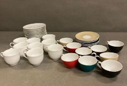 Nine Coloured expresso cups with nine saucers and ten white expresso cups and saucers.