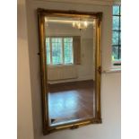 A gilt wall mirror with scrolling details to corners (74cm x 135cm)