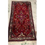 A hand knotted Iranian carpet/rug (220cm x 104cm)