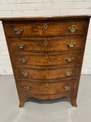 A George III style serpentine chest of drawers with graduating drawers and brass drop handles (