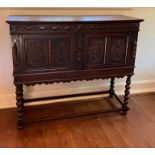 An oak carved panel court cupboard. The lower section on turned supports and frieze (H123cm W145cm