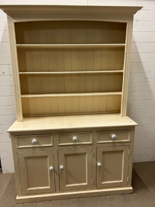 A painted pine dresser with white ceramic knob handles, three shelf plate rack over three drawers