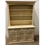 A painted pine dresser with white ceramic knob handles, three shelf plate rack over three drawers