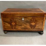 An antique tea caddy with ornate fruit wood shell decoration.