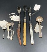 A selection of silver items to include three toasting forks and three mustard or salt spoons
