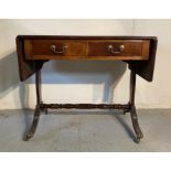 A mahogany drop leaf sofa table on castors with lions paw feet (H76cm W93cm D60cm)