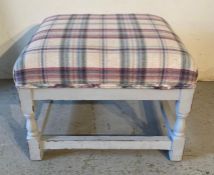 A checkered upholstered foot stool