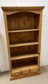 A pine four shelf open bookcase with three small drawers (H181cm W93cm D36cm)