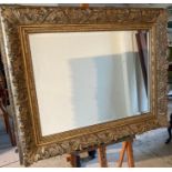 A heavy gilt framed mirror with scrolling frame 86cm x 105cm