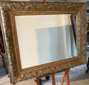 A heavy gilt framed mirror with scrolling frame 86cm x 105cm