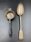 A silver spoon (London 1820 Makers Mark R.P) and a silver tea strainer with ebonised handle