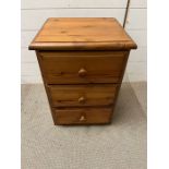 A pine three drawer bedside (H60cm W42cm D37cm)