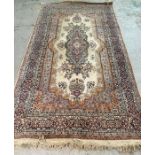 A beige ground wool rug with central medallion brown and blues (150cm x 270cm)