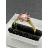 An 18ct gold daisy style ring with central diamond and eight rubies.