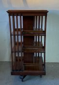 A mahogany revolving bookcase on castors (H116cm W60cm D60cm)