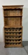 A pine dresser with twenty five bottle rack to base (H157cm W68cm D31cm)