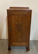 An oak pot cupboard with two shelves with acorn detail carving