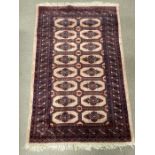 A beige ground rug with a geometric medallion design 156cm x 98cm