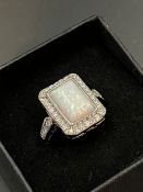 A silver rectangular opal ring