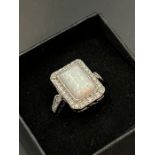 A silver rectangular opal ring