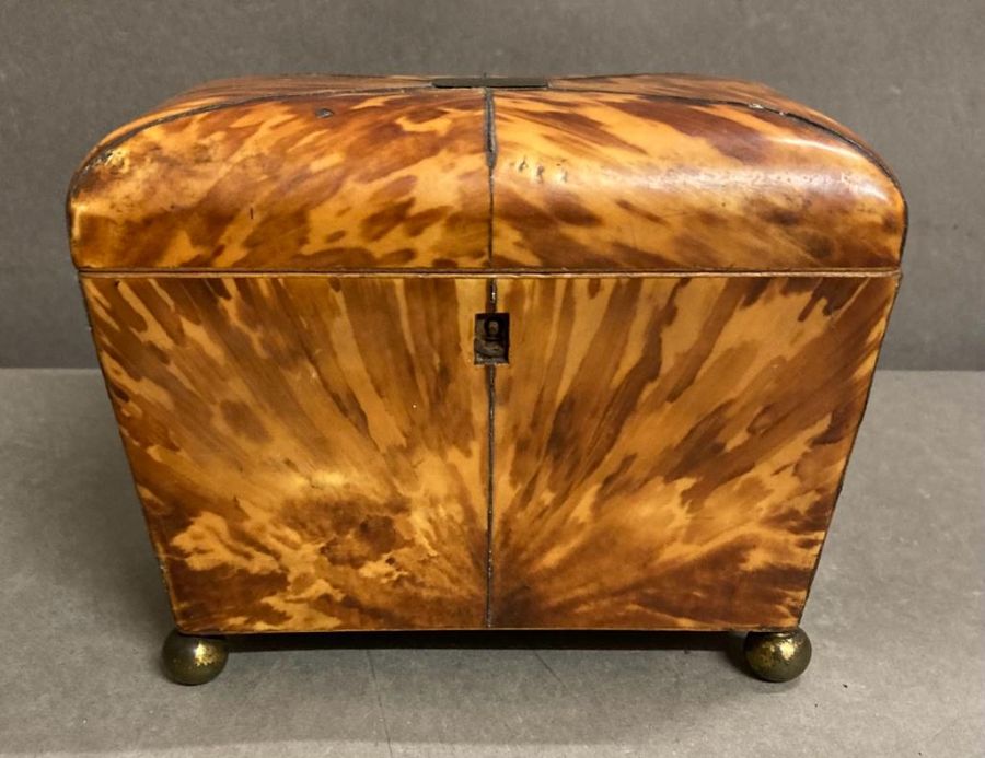 An antique tortoiseshell tea caddy on brass ball feet AF