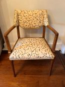 An Arts and Crafts open armchair with floral seat pad